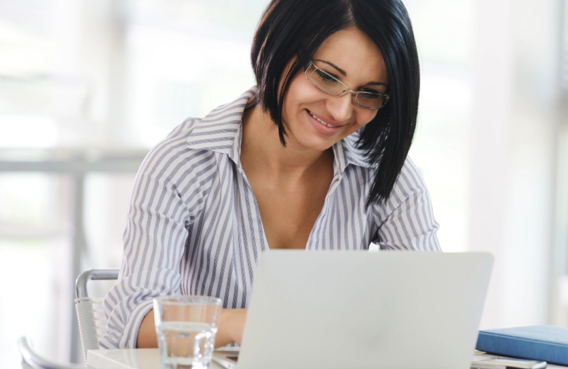 A woman sitting at a desk using a laptop
