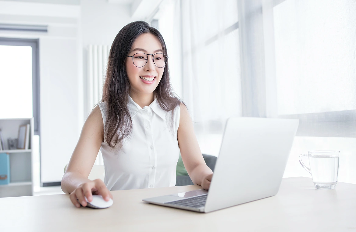 A woman with glasses in an office resetting a password on her laptop